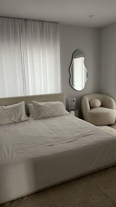 a white bed sitting next to a window in a bedroom