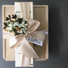 a bouquet of flowers tied to a wooden box with a ribbon on the front and side