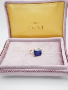 The Georgian-Victorian Emerald Cut Blue Sapphire & Blackened Gold East West Button Back Collet Ring—a timeless engagement piece inspired by the grace of the Georgian and Victorian periods. This ring photographed features a stunning 4 ct lab-grown sapphire in a Georgian cut-down collet setting and button back. It's not just an engagement ring; it's a versatile piece designed for stacking and layering with other styles. Lab Grown Gems: Our lab grown stones are not synthetic, or treated. These are Formal Sapphire Ring With Cushion Brilliant Cut, Formal Sapphire Ring With Brilliant And Cushion Cut, Timeless Sapphire Ring As Gift, Timeless Sapphire Wedding Ring, Timeless Sapphire Ring For Gift, Classic Sapphire Baguette Cut Ring, Formal Sapphire Ring With Cushion Diamond Cut, Formal Sapphire Ring With Cushion Cut, Timeless Emerald-cut Sapphire Ring In Sterling Silver