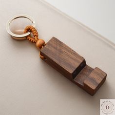 a wooden keychain with a ring attached to it on a white cloth background