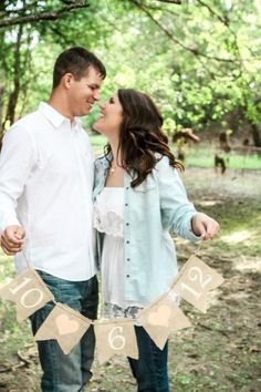 a man and woman are standing in the woods