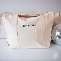 a white bag sitting next to a disco ball on top of a table with the word emra written on it