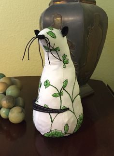 a stuffed animal sitting on top of a wooden table next to eggs and a vase