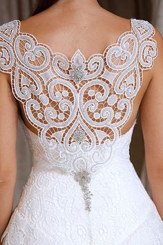 the back of a woman's wedding dress with an intricate lace design on it