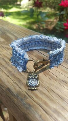 an owl bracelet is sitting on top of a wooden table