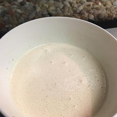 a white bowl filled with liquid sitting on top of a counter