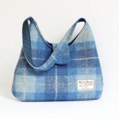 "This bag is made with genuine Harris Tweed 100% wool fabric in a blue tartan pattern. It is lined with a grey or blue cotton fabric and closes with a magnetic snap on the flap. It is fully interfaced and interlined to give it structure and durability. It has 2 pockets inside, one is fastened by a zipper. The strap is the ideal size to either carry the bag in your hand or on your shoulder. SIZE: 33cm wide x 29cm tall (13\" x 11.5\"), approx. strap: 50cm (20\") The coin purse in the picture is no Harris Tweed Bag, Macleod Tartan, Eco Friendly Handbags, Tweed Purse, Tweed Bag, Cotton House, Cork Bag, Handmade Purse, Blue Tartan