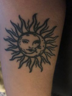 a tattoo on the leg of a person with sun and moon design in black ink