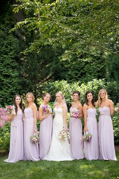 a group of women standing next to each other on top of a lush green field