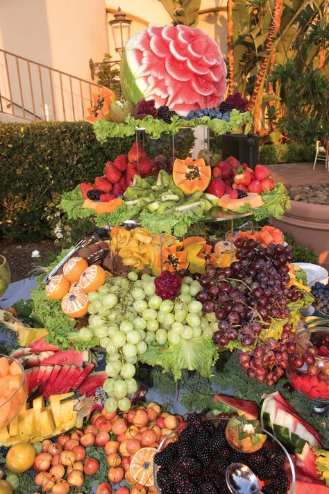 elaborate-and-luxurious-tower-of-fruit-with-cascading-grapes-and-carved-watermelon-at-cocktail-hour Fruit Tower For Wedding, Fruit Waterfall Display, Large Fruit Display, Grapes On Wedding Table, Fruit Cascade, Fruit Station, Huge Charcuterie Board Wedding, Cheese Station, Grazing Station