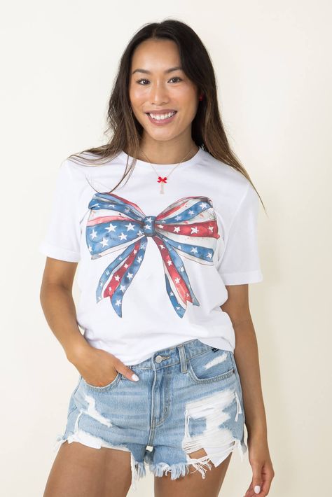 Showcase your patriotism all season long with this Americana Bow Graphic T-Shirt for Women in White! Stylish and comfy, it features short sleeves, ribbed crew neckline, and a screen-printed Americana Bow graphic in a fun red, white and blue pattern. Perfect for making a statement or just loungin' around! Features: A. Blush Style: 11931X-TS-WHITE Color: White 100% Cotton Women’s graphic tee Short sleeves, ribbed crew neckline Screen printed graphic of an American bow in a red, white and blue pattern Measurements from size small: Length from front shoulder: 28” Chest: 34" Machine wash warm inside out, tumble dry low Paint Therapy, White And Blue Pattern, Bow Graphic, Women In White, Fourth Of July Shirts, Bow Shirts, T Shirt For Women, White Style, Blue Pattern