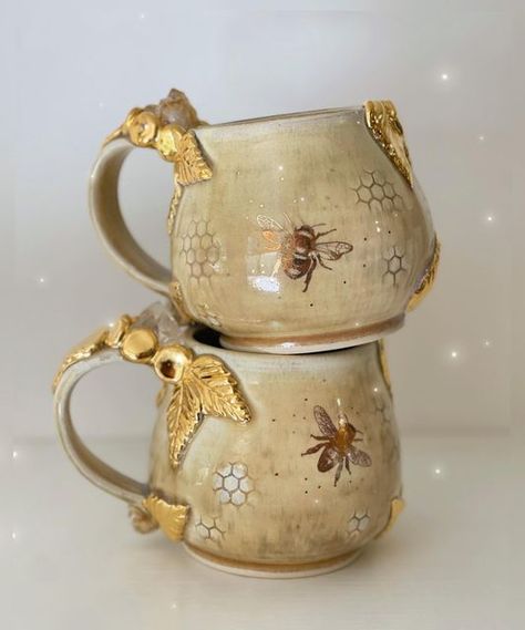 Lauren Lewis on Instagram: "These mugs are begging to be used for a cup of hot tea with honey as the weather turns cool. 🍂🍯🐝 . . . #clay #handmadehome #honeybee #potterymaking #pottery #ceramicart #ceramic #honeycomb #bees #beeswax #beekeeping #beeart #artistsupport #intentionalart #designinspo #honey #honeybees #cottagecore #boho #crystals #citrine #cottagecoreaesthetic #quartz #cottagegarden #maker #naturewitch #witchyvibes #mug" Bee Clay Mug, Beehive Mug, Honey Comb Pottery, Bee Hive Pottery, Bee Ceramics Pottery, Cottagecore Ceramics, Beehive Pottery, Ceramic Bees, Cozycore Aesthetic