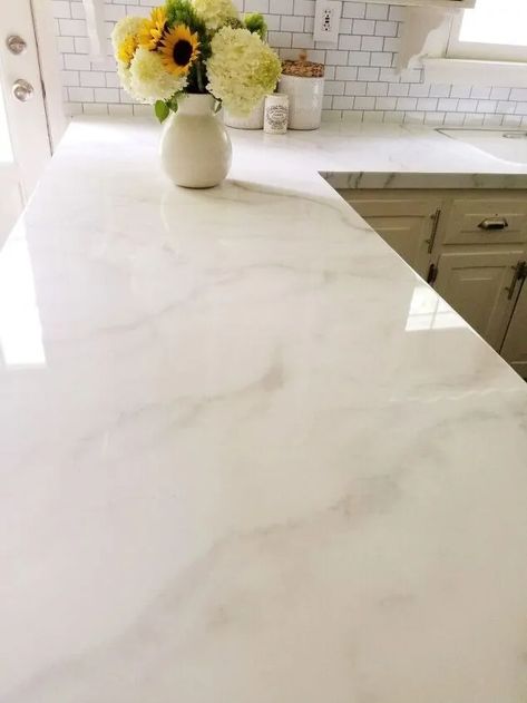 An overview of 9 types of white countertops for your kitchen! This article compares marble, quartz, quartzite, granite, but also concrete, resin epoxy, lava, laminate, and recycled glass countertop. White Shalestone Formica Countertop, Envi Quartz Countertops, Liberty Gold Quartz Countertop, Timeless Quartz Countertops, Marbella White Quartz Countertops, White And Gold Countertops, White Marble Countertops Kitchen, Tile Countertops Redo, White Epoxy Countertop