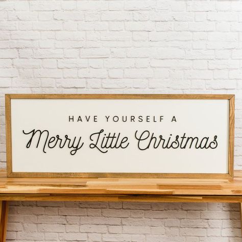 This beautiful 13x35 inch rectangular sign is a beautiful statement piece to add to your Christmas decorations. It has a beautiful weathered walnut stain, 3D laser-cut matte black lettering, and a white background. The font pairing is darling. You can hang it on a wall, put it on a bench, display it on an entry table, or even give it as a gift! You'll be singing the popular Christmas song after you display this beautiful sign! PRODUCT DETAILS Stain: Weathered Walnut Colors: White Background, Bla Neutral Christmas Signs, Christmas Acrylic Sign, Long Christmas Signs, Christmas Cricut Sign, Black And White Christmas Signs, Simple Christmas Signs, Have Yourself A Merry Little Christmas, Christmas Sayings Signs, Large Christmas Signs