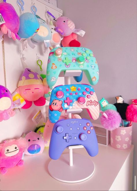 Its the little things. This is so cute for displaying all your cute controllers! #gamergirl #gamersetup #gamergirlsetup #kawaii #pastelgoth #pastelcore #pastelgamer #nintendoswitch #gamer #gamerneeds #organizedhome #kirby Cute Game Controller, Kawaii Gamer Setup, Xbox Setup Ideas, Kirby Gaming Setup, Xbox Controller Aesthetic, Kawaii Gamer Aesthetic, Xbox Gaming Setup, Xbox Controller Stand, Gamer Headset