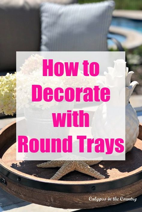 Simple decorating tips and ideas for round trays. Decorate a round tray with seasonal accessories. From kitchen counters to coffee tables and centerpieces, a round tray makes a great base for decorating! Photos of round trays included. Round Tray On Coffee Table, Styling A Tray On A Coffee Table, Decor For Ottoman Tray, Coffee Table Trays Ideas Living Room, Coffee Table Scapes Ideas, How To Style A Tray Living Room, How To Style Trays, Round Tray Centerpiece Ideas Kitchen Table, Fall Round Tray Decorating Ideas