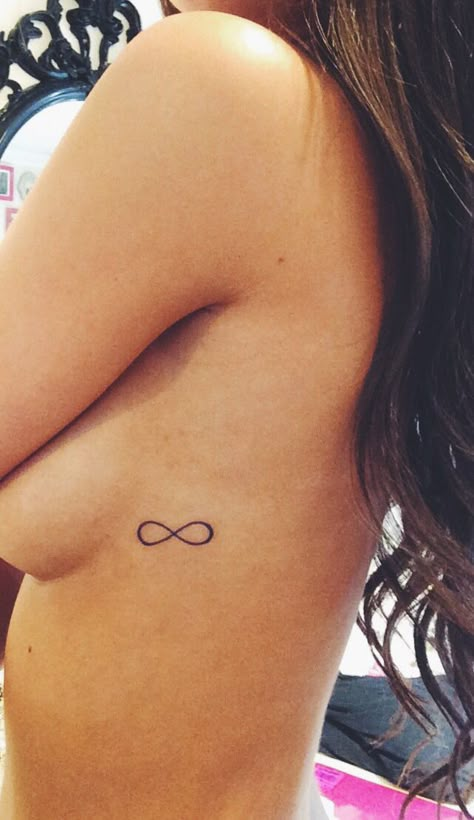 Small and simple infinity tattoo Infinity Tattoo Rib Cage, Tattoo Ideas Female Small Infinity, Small Infinity Wrist Tattoos For Women, Infinity Rib Tattoo, Infinity Tattoo Placement, Infinity Small Tattoo, Small Tattoos Easy To Hide, Fine Line Infinity Tattoo, Simple Infinity Tattoo