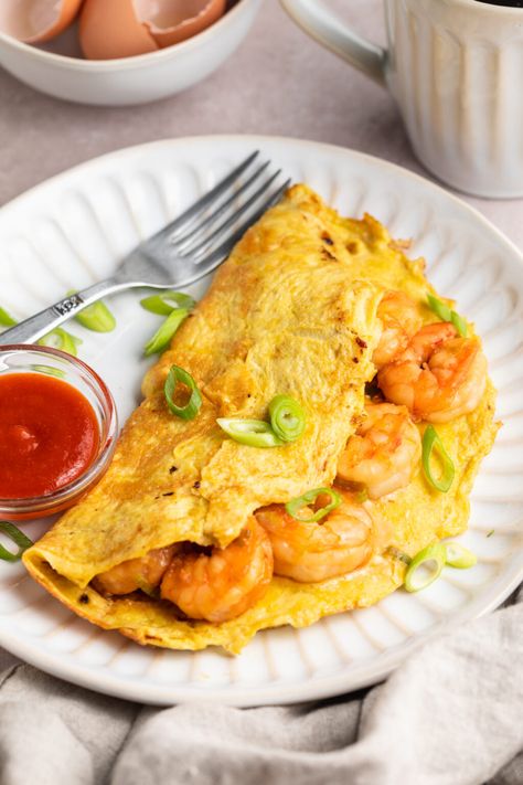 This simple shrimp omelette is a delicious, high-protein way to start the day. Featuring tender shrimp sautéed with green onions in savory soy sauce and rice wine vinegar, enclosed in a fluffy mixture of eggs and milk, this easy entrée is full of flavor and ready in no time at all. Omlet With Shrimp, Fish And Eggs, Shrimp Omelette Recipe, Shrimp Omelet Recipes, Breakfast Shrimp Ideas, Shrimp Breakfast Recipes, Shrimp Breakfast, Breakfast Shrimp, Shrimp Omelette