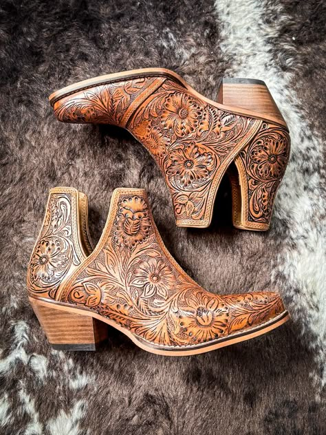 Step into the epitome of Southwestern flair with these Western leather booties, meticulously hand-tooled to highlight a stunning blend of rich bourbon hues. Featuring classic cowboy heels and convenient side slits, they blend traditional craftsmanship with modern ease. The intricate design, showcasing a pattern of desert blossoms, adds a distinctive touch of elegance. Ideal for transforming any ensemble, these tooled boots exude statement-making style with every step. 2" slanted heel. 6-11 not a Tooled Boots, Cowboy Heels, Hay Bag, Classic Cowboy, Pick Your Poison, Wrap Boots, Horse Boots, Western Booties, Western Leather