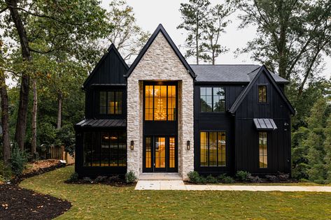 Black siding and windows accented with stone entrance Black White And Stone Exterior, Black House With Stone Accents, White Black House Exterior, Stone And Black House Exterior, Black Siding House Exterior, Black Exterior House With Stone, White House Black Stone Exterior, Black House With White Stone, Black And Stone Exterior