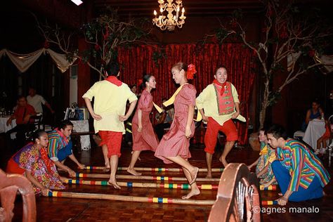 The filipino folk dance called "tinikling," is a traditional filipino dance. It involves both men and women with sets of bamboo sticks sometimes crossed over each other. The bamboo sticks are hit together and on a ground usually in a rhythmic tune while the dancers step back and forth in between the spaces . Tinikling involves more props, feet movement and singing while Islamic dancing has many hand movements and very up-beat music. Filipino Folk Dance, Year End Party Theme, Tinikling Dance, Filipino Dance, Philippine Traditions, Cool Powerpoint Backgrounds, Culture Identity, Pinoy Culture, Cool Powerpoint