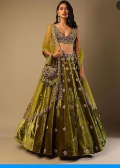 Lehenga Choli for Wedding Wear is stunningly embroidered in dabka, tilla, and sequins work on white raw silk choli paired with Raw Silk Green Lehenga and Net Pink Dupatta. ﻿A blossoming pink hue dupatta is paired up with a handcrafted mastery of pearls, zardosi, and sequins laid over an emerald green lehenga and a white choli in pure raw silk. Choli: Beautiful dress is gonna make your big day more beautiful in its design and styling having embroidered choli in without sleeves inc Chaniya Choli Designs, Green Lehenga Choli, Long Gown For Wedding, Velvet Lehenga, Wedding Lehenga Designs, Kalki Fashion, Green Lehenga, Choli Designs, Embroidered Velvet