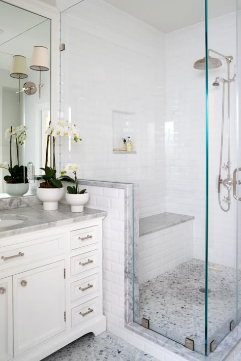 A glass-enclosed shower is fitted with a bench is this traditional master bathroom space. The potted flowers on the vanity are also seen in the kids' bathroom, adding continuity between the spaces. Minimalist Small Bathrooms, Makeover Kamar Mandi, Beautiful Master Bathrooms, Small Bathroom With Shower, Master Bath Ideas, Master Bathrooms, Shower Bathroom, Bathroom Shower Tile, Bathroom Remodel Shower