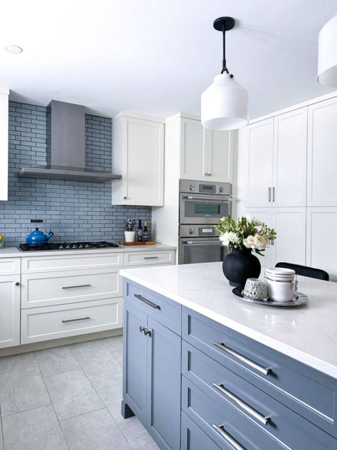 Soft white perimeter cabinets and a contrasting blue-gray kitchen island. The painted blue-gray finish of the island cabinetry balances the cool blue backsplash tile, and blends harmoniously with the sprinkle of stainless steel hardware and pops of matte black throughout the space. Everything is layered on top of a new just-right gray porcelain floor tile: not too cool, not too warm. Blue Kitchen Cabinets Grey Floors, Blue Cabinets Dark Countertops, Blue Backsplash Tile, Contrasting Kitchen, Contrasting Kitchen Island, Grey Blue Kitchen, Blue Kitchen Island, Grey Kitchen Floor, Two Tone Kitchen Cabinets