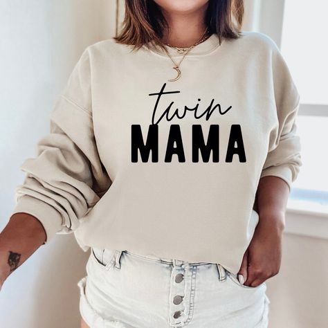 "The \"Twin Mama Sweatshirt\" is a sturdy and warm crewneck sweatshirt bound to keep you warm in the colder months. These cozy sweatshirts make a great gift for anyone! A pre-shrunk, classic fit sweater that's made with air-jet spun yarn for a soft feel and reduced pilling. Sweatshirt details: * 50% cotton, 50% polyester * Pre-shrunk * Classic fit with no center crease * 1x1 athletic rib knit collar with spandex * Air-jet spun yarn with a soft feel and reduced pilling * Double-needle stitched co