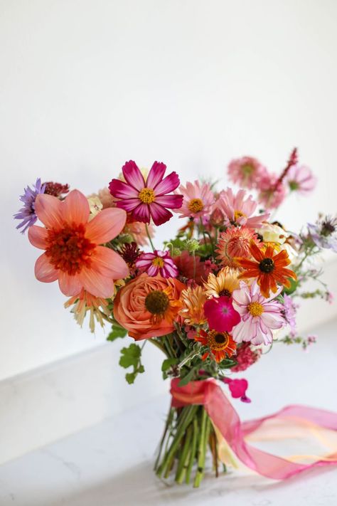 Colourful natural bridal bouquet sits on a marble sideboard Natural Bouquet Wedding, Bright Wedding Bouquet, Summer Bridal Bouquet, Wildflower Bridal Bouquets, Orange Bridal Bouquet, Orange Wedding Bouquet, Orange And Pink Wedding, Colorful Bridal Bouquet, Bridal Bouquet Summer