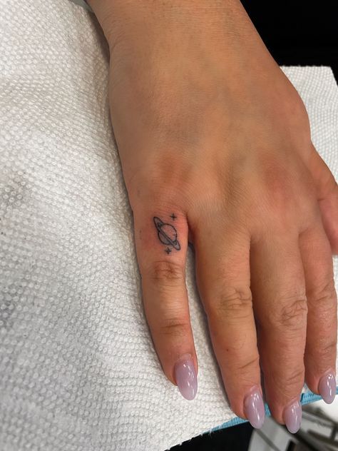 Tiny finger tat saturn tattoo space stars Universe Finger Tattoo, Space Tiny Tattoos, Saturn Ankle Tattoo, Saturn Hand Tattoo, Saturn Tattoo With Stars, Dainty Saturn Tattoo, Mini Saturn Tattoo, Saturn Heart Tattoo, Planet Hand Tattoo