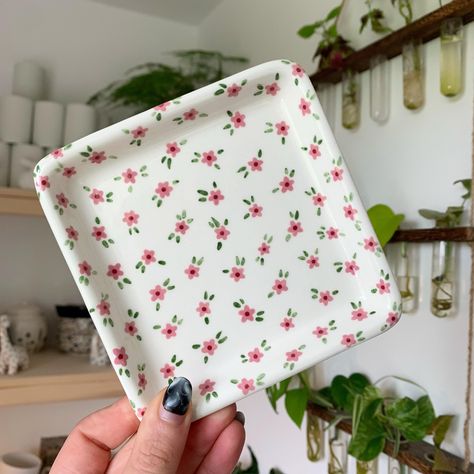 Square trinket tray with little pink flowers 🌸✨🌱 Lots of things available on my website now - link in bio ✨🥰 #art #artist #ceramics #pottery #painting #illustrator #ceramicstudio #potterytiktok #potterypainting #painter #trinkettray #smallbusiness Cute Tray Painting Ideas, Ceramic Trinket Tray, Jewelry Tray Painting Ideas, Pottery Painting Trinket Dish, Trinket Tray Painting Ideas, Pottery Painting Jewelry Dish, Pottery Trinket Dish, Ceramic Painting Flowers, Ornaments Painting Ideas