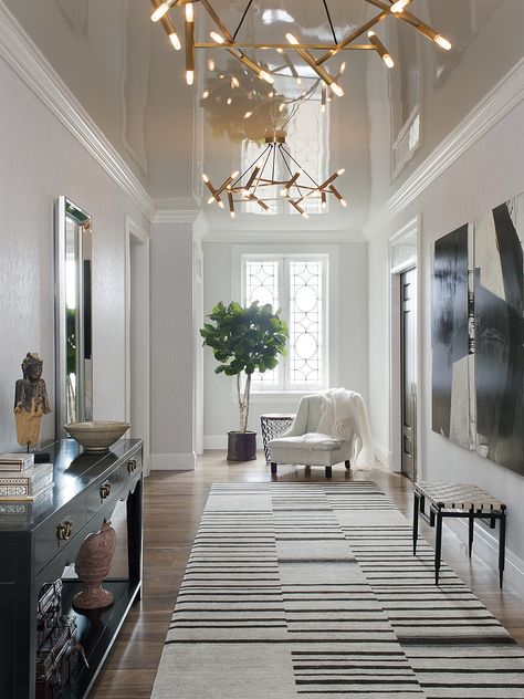 A high-gloss lacquered ceiling reflects the dramatic entry gallery. Transitional Entry, Entrance Hall Furniture, Modern Entryway Decor, Hall Furniture, Entry Design, The World Of Interiors, Entryway Lighting, Modern Entryway, Entry Way Design