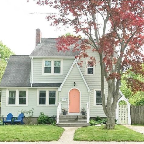 This classic cottage uses pops of color by adding a fun peach color to the front door and royal blue chairs. New England Homes Exterior, Exterior House Paint Schemes, House England, Best Exterior House Paint, Benjamin Moore Exterior, Exterior Paint Ideas, Best Exterior Paint, Farmhouse Paint Colors, Paint Colors For House