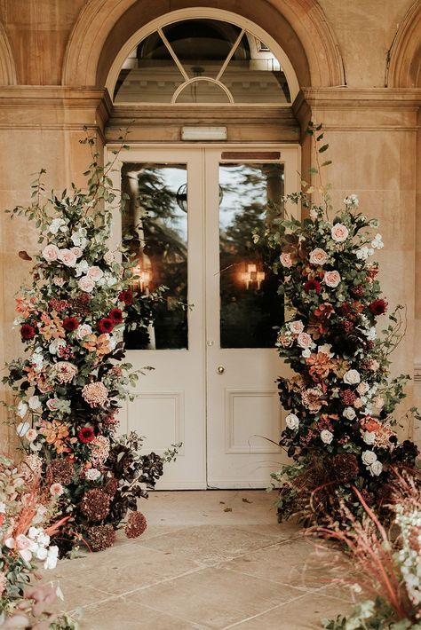 Pale pink and red autumnal wedding flower column decorations Flower Arches For Weddings, Light Burgundy Wedding, Wine And Gold Wedding Theme, Fall Pinks Wedding, Fall Color Flowers Wedding, Cream And Maroon Wedding, Ballroom Wedding Flowers, Wedding Flower Entrance, City Wedding Flowers