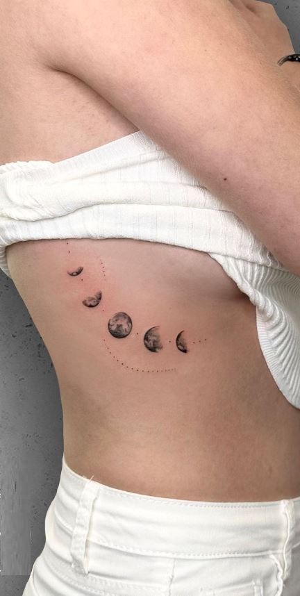 << Check out more Moon Phase Tattoos, Ideas and Meanings #tattoomenow #tattooideas #tattoodesigns #tattoos #Moonphase #Moonphasetattoo Moon Phase Tattoo Ribs, Planets Down Spine Tattoo, Moon Changes Tattoo, Red Moon Phases Tattoo, Moon Belly Tattoo, Ribcage Moon Tattoo, Moon Phase Rib Tattoo, Stages Of The Moon Tattoo, Moon Phases Down Spine Tattoo