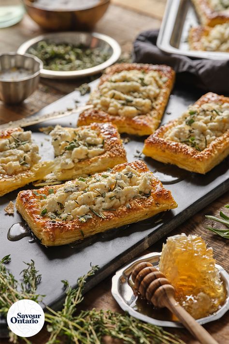 This Herbed Ricotta and Feta Puff Pastry Tart recipe, made with Ontario Ricotta and Feta cheese, is incredibly versatile and can be served up for any occasion. Notes of sweetness from the honey and puff pastry compliment the salty hits from the feta cheese with every bite. Let your imagination run wild and reap the rewards by topping these tarts with your favourite ingredients - like tomato, basil, and even roasted chicken - the sky’s the limit! Find this recipe and more at savourontario.ca! Puff Pastry Salty Recipes, Puff Pastry With Ricotta Cheese, Ricotta Puff Pastry Recipes, Puff Pastry Recipes Savory Tart, Puff Pastry Ricotta, Potato Puff Pastry, Ricotta Puff Pastry, Savoury Puff Pastry, Feta Pastry