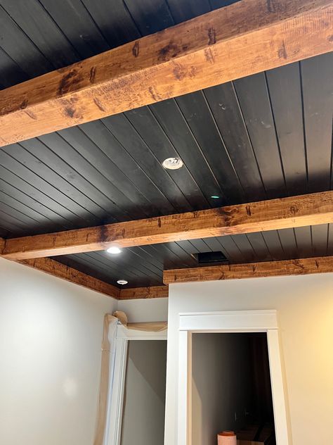 Wood Beam Basement Ceiling, Basement Wood Beams, Industrial Beams Ceiling, Black Tin Ceiling Ideas, Black Ceiling Vaulted, Ceiling Support Beam Ideas, Rooms With Black Ceiling, Wood Beam Living Room Ceiling, Rustic Shiplap Wall Bedroom