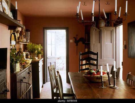 Country terracotta dining room wooden table chairs wrought iron chandelier Interiors rooms traditional period features furniture rustic oak Stock Photo Terracotta Walls Dining Room, Terra Cotta Dining Room, Terracotta Dining Room, Terracotta Walls, Dark Dining Room, Wrought Iron Chandelier, South Street, Wooden Table And Chairs, Iron Chandelier