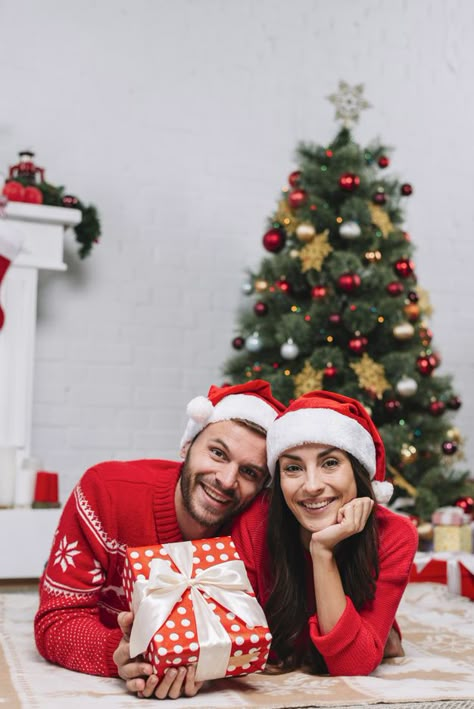 Happy couple near christmas tree | Premium Photo #Freepik #photo #background #christmas #christmas-tree #christmas-background 3 Family Christmas Photos, Christmas Photos At Home Couples, Christmas Tree Poses Couple, Christmas Photoshoot For Couples, Xmas Couple Photoshoot, Family Photoshoot Christmas Ideas, Couple Christmas Photoshoot Studio, Couple Christmas Tree Photos, Christmas Tree Couple Pictures Indoor