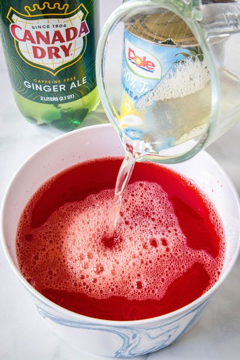 This frozen holiday punch with fizzy ginger ale, pineapple juice, and cherry Jello is an easy Christmas punch the whole family can enjoy! #holiday #punch #christmas Punch Recipes With Jello, Frozen Jello Punch Recipe, Christmas Punch With Pineapple Juice, Jello Punch Recipes, Frozen Juice Concentrate Recipes, Christmas Punch With Sherbet, Gingerale Punch, Ice Cream Punch Recipes, Frozen Party Punch