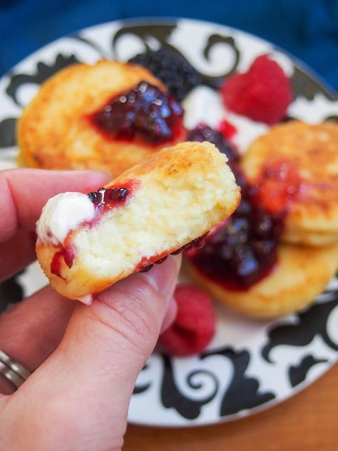 Syrniki are small, thick Ukrainian/Russian sweet cheese pancakes. They might not have a lot of ingredients and look a bit unassuming, but these little bites are soft, fluffy and deliciously good. Ukrainian Cheese Pancakes, Syrnyky Recipe, Siberian Food, Sirniki Russian, Sirniki Recipe, Syrniki Pancakes, Syrniki Recipe, Russian Sweets, Greek Goodness