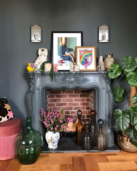 Layer artwork, houseplants and decor for a maximalist look. Maximalist Decor Fireplace, Quirky Mantle Decor, Witchy Mantel Decor, Maximalist Fireplace Decor, Mantle Decor Maximalist, Maximalist Fireplace Mantle, Eclectic Fireplace Decor, Maximalist Mantle Decor, Colorful Mantle Decor