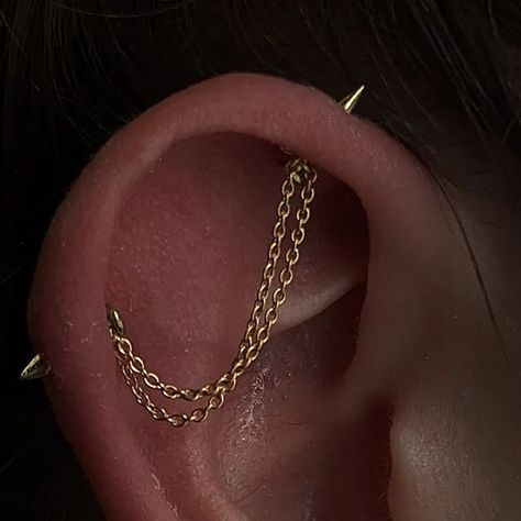 Hazel 🌷 on Instagram: "Chains , Spikes and Springy leaves 🧡 Awesome upgrade for Kirsty for piercings long healed. Awesome spikes in the industrial from @junipurrjewelry paired with the Florence in yellow gold for the lobes! Topped off with a custom double industrial chain made by me ⭐ So fun!!!! Thank you for the trust! #ukbodypiercer #earcuration #earstyling #earchains #scottishpiercer #edinbrughpiercer #styledear" Industrial Piercing With Chain, Piercings Ear Industrial, Ear Piercings With Industrial, Double Industrial Piercing, Jacob's Ladder Piercing, Lobe Piercing Ideas, Edgy Piercings, Chain Industrial Piercing, Industrial Piercing Chain