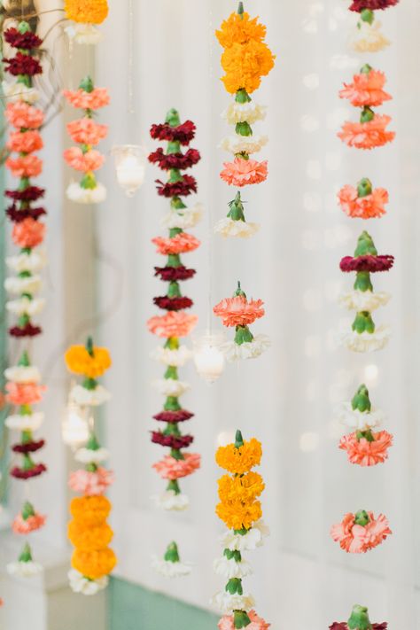 Draped over the table, swagged around the ceiling or lined up together like a curtain, flower garlands are everywhere. (Searches for flower garland +1154%) Indian Wedding Florals, Carnation Decor, Carnation Garland, Indian Decoration, Flowers Hanging, Tafel Decor, Backdrop Photography, Indian Inspired, Indian Decor