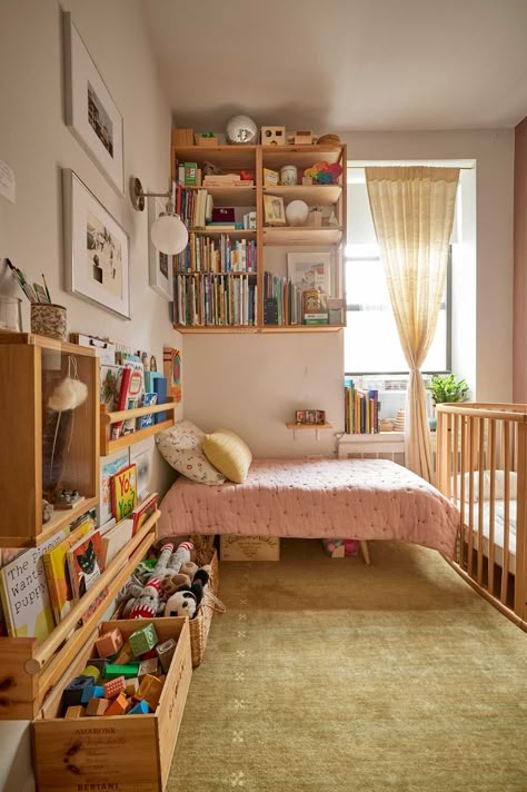 The wood shelving and book racks were made by Alex.  Credit: <a href="https://www.apartmenttherapy.com/authors/erin-derby">Erin Derby</a> Small Montessori Room, Small Bedroom And Playroom Combo, Kids Bedroom Bookshelf Ideas, Nursery In One Bedroom Apartment, Diy Toddler Bookshelf, Two Under Two Bedroom, Montessori Kids Bedroom, Small Home With Kids, Small Kid Room Ideas