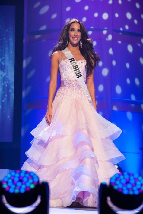 Miss Florida Teen USA 2017, Victoria DiSorbo looks like a vision in this pink gown. The ruffled layers of the skirt make the dress look light and airy and provide natural movement while DiSorbo walked on stage. The gown features a darker pink belt made of stones that give DiSorbo a little more shape in the gown. Her big, bouncy curls and light makeup complement this look perfectly! Best Evening Gowns, Big Bouncy Curls, Pageant Tips, Pageant Evening Gowns, Miss Florida, Cute Formal Dresses, Runway Gowns, Teen Usa, Pink Gown