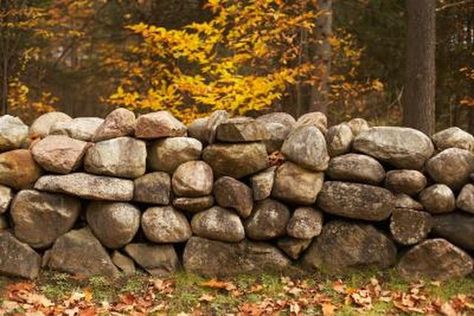 Steep slopes and small cliffs of dirt on your property often erode under excessive rainfall, leaving mud and rock on paths, lawns and driveways. Building retaining walls prevents... Rock Wall Landscape, Stone Wall Backdrop, Rock Wall Gardens, Building A Stone Wall, Boulder Rock, Rock Retaining Wall, Landscape Planning, Building A Retaining Wall, Stone Retaining Wall