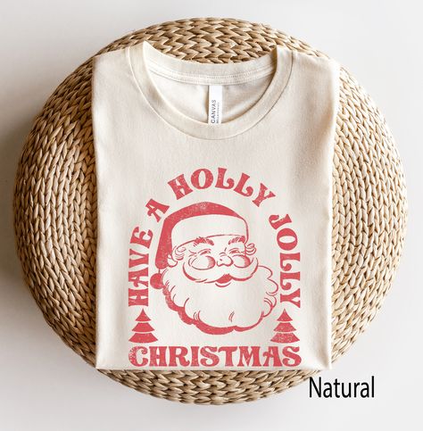 Retro Santa Tee, Santa Tee, Vintage Graphic Tee, Merry Christmas Shirt, Vintage Santa Graphic Tee, Classic Christmas Tee -- Graphic is distressed for a vintage vibe. SIZE UP for an OVERSIZED look (see size chart in listing photos). Looking for more Christmas and Winter themed apparel? Check these out: https://www.etsy.com/shop/TheGraphicPeach?ref=seller-platform-mcnav§ion_id=30496778 Our shop uses direct-to-garment printing to make our products. The design ink is sprayed on, then allowed to soak Winter Graphic Tees, Christmas Graphic Tee, Diy Christmas Shirts For Family, Cricut Christmas Shirts, Vanilla Christmas, Christmas Graphic Tees, Vintage Christmas Shirt, Santa Graphic, Retro Christmas Shirt