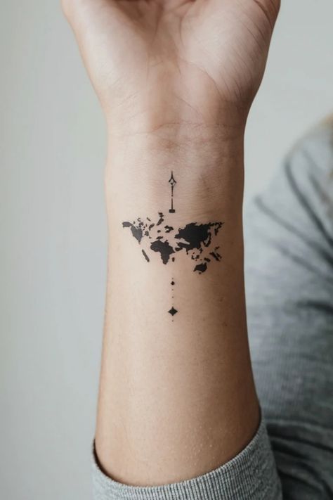 World map tattoo on forearm with a small compass design above. Mini Tattoo Location, Small Map Tattoo, Adventure Awaits Tattoo, Travel Stamp Tattoo, Treasure Map Tattoo, Wrist Small Tattoo, Hand Small Tattoo, Small Tattoo Ideas Women, Map Tattoo Ideas